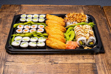 Sushi black plate on wood table,