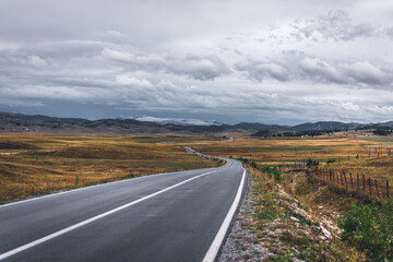 Empty mountain road on cloudy day. Dramatic and picturesque scene. Location famous place National park Durmitor, Montenegro, Balkans. Village Zabljak, Europe. .