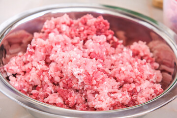 A man mixes minced meat in a bowl with his hands. Preparation of minced beef and pork for cutlets, meatballs, chops.
