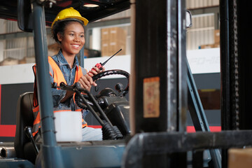 Women labor worker at forklift driver position with safety suit and helmet happy enjoy working in...