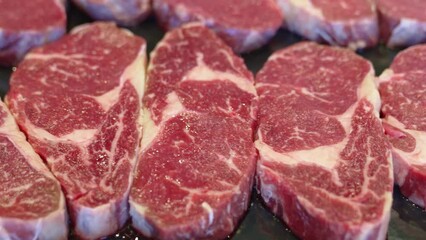 sliced pieces of raw meat to make fried steaks on baking tray.
