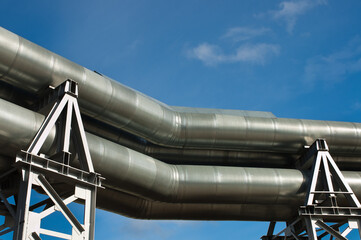 pipeline, in the photo pipeline close-up against a background of green forest and blue sky.