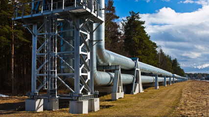 pipeline and power line pylon, in the photo, pipeline close-up, power line pylon and blue sky in the background