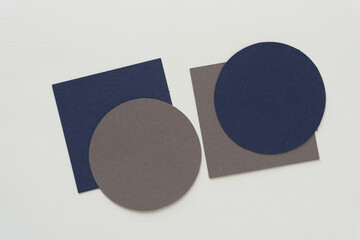 gray and blue paper circles and squares on blank paper