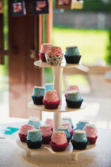 Muffins with pink cream and signs on a tray