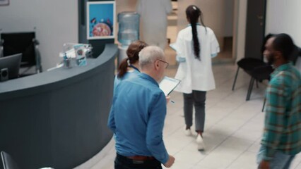Impatient group of people asking to write healthcare report and waiting in busy hospital reception lobby. Being in medical clinic waiting area to attend consultation appointment. Handheld shot.