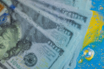Macro view of blurred view of hundred dollar bills under water. 