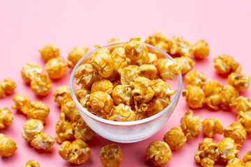 Honey caramel popcorn on pink background.