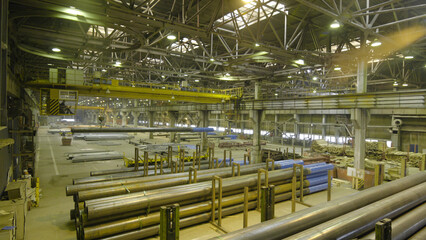 Yellow Indoor Crane. Work hanging of a crane at the plant for the production of pipes