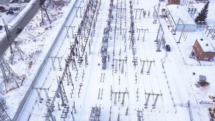 Rows of electric poles of substation. Action. Top view of small electrical substation with rows of transformers in suburbs. Suburban electric substation in winter