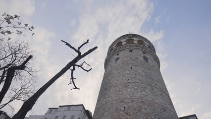 Bottom view of Galata Tower. Action. Ancient stone tower on background of blue sky. Historical...