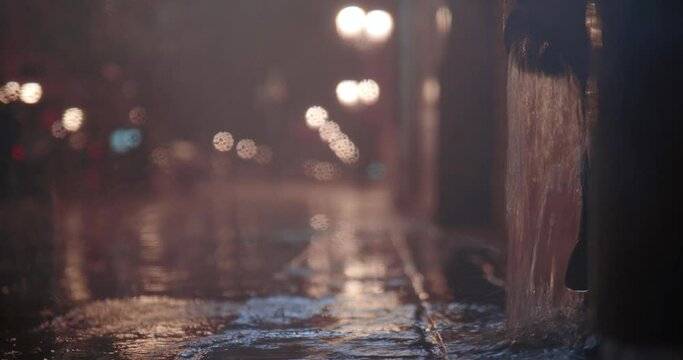 Street downpipe with water pouring after heavy night rain