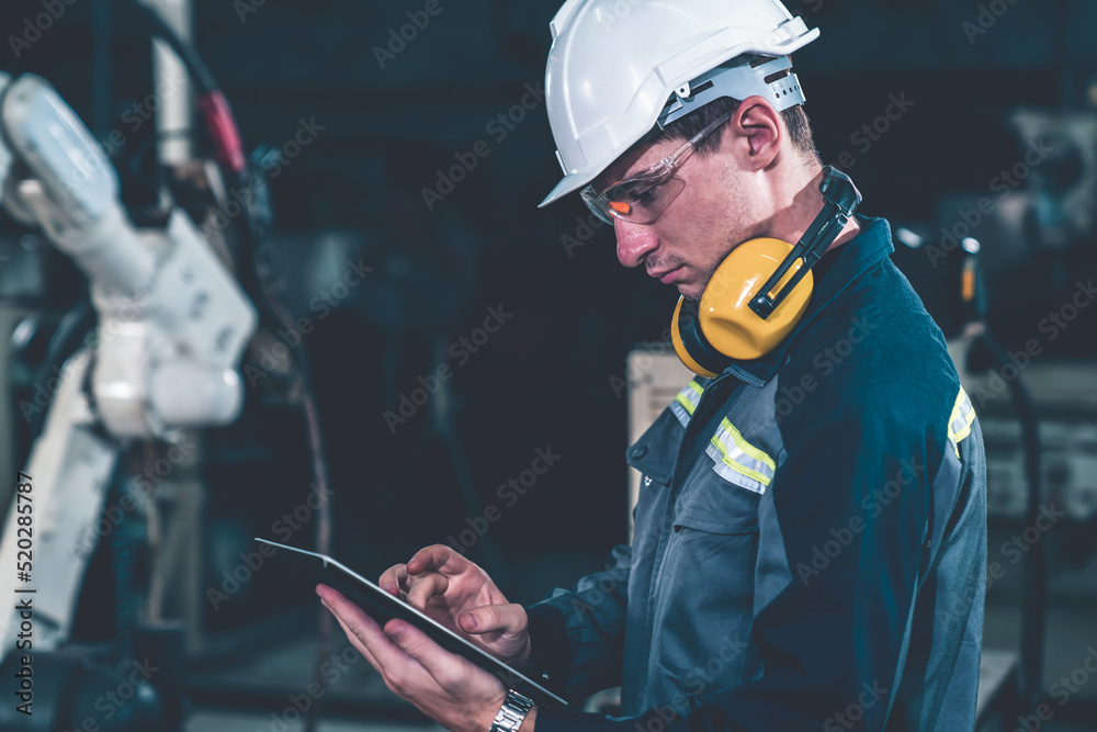 Poster young factory worker working with adept robotic arm in a workshop . industry robot programming softw