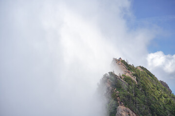 霧の中に悠然とそびえ立つ西日本最高峰の石鎚山。夏山の美しい風景。