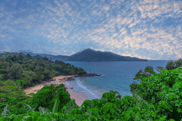 Fototapeta na wymiar Colourful Skies Sunset over Head Laem Sing Beach in Phuket Thailand. This Lovely island waters are turquoise blue waters, lush green mountains colourful skies and beautiful views of Pa Tong Patong