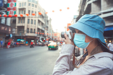 Young adult asian woman traveller backpack using camera photography in city