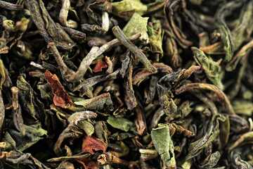 Premium green loose leaf tea as a background. Texture of dry green tea leaves. Extreme macro mode

