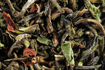 Premium green loose leaf tea as a background. Texture of dry green tea leaves. Extreme macro mode

