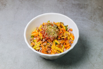 Korean food Bibimbap, Rice topped with sautéed beef and a variety of colorful vegetables that is mixed at the table with spicy gochujang. A hint of sesame oil helps bring out the flavor.