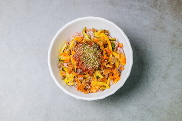 Korean food Bibimbap, Rice topped with sautéed beef and a variety of colorful vegetables that is mixed at the table with spicy gochujang. A hint of sesame oil helps bring out the flavor.