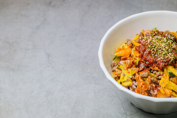 Korean food Bibimbap, Rice topped with sautéed beef and a variety of colorful vegetables that is mixed at the table with spicy gochujang. A hint of sesame oil helps bring out the flavor.