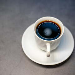 Close up of hot americano in white cup looking, and feel so delicious on gray table background.
