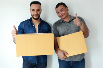 Happy couple man in action trump up hand with holding box for moving house