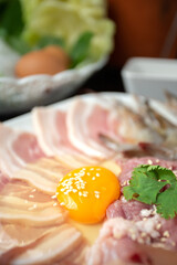 Sliced raw pork, fresh chicken eggs and fresh vegetables, Isaan Thai food ''chim chum'' is a famous Thai dish with a spicy dipping sauce.