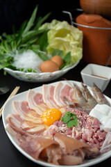 Sliced raw pork, fresh chicken eggs and fresh vegetables, Isaan Thai food ''chim chum'' is a famous Thai dish with a spicy dipping sauce.