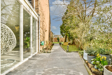 Neat paved patio with sitting area and small garden near wooden fence