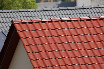 Typical tiled roof and chimney against blue sky