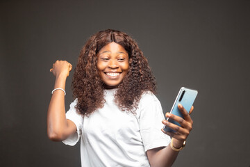 Young african american woman holding mobile phone screaming proud, celebrating victory and success...