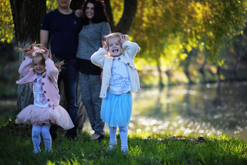 Fototapeta premium Leaf fall in the park. Children for a walk in the autumn park. Family. Fall. Happiness.