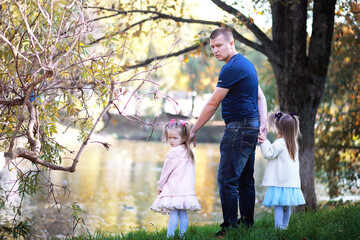 Fototapeta premium Leaf fall in the park. Children for a walk in the autumn park. Family. Fall. Happiness.