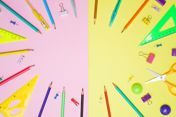 Supplies set on table, creative tools for school creative work on yellow and pink background stationery, colored pencils pens and markers copy space, flat lay