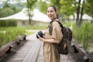 Asian girl backpack in nature the mountains of Khao Yai , Relax time on holiday concept travel,Photographer Travel Sightseeing Wander Hobby Recreation Concept
