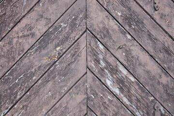 Fototapeta na wymiar Old wooden door wall fragment. Weathered decks rustic style diagonal background texture