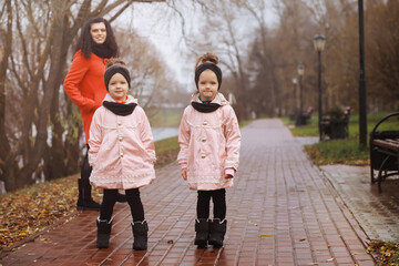 Young family on a walk in the autumn park on a sunny day. Happiness to be together.