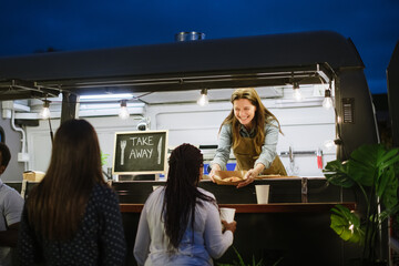 Cheerful vendor serving food to customer