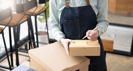 Startup Entrepreneurship Small Business SME Freelance Young lady working at home with boxes and laptop online Marketing Packaging SME Shipping Ecommerce Concepts