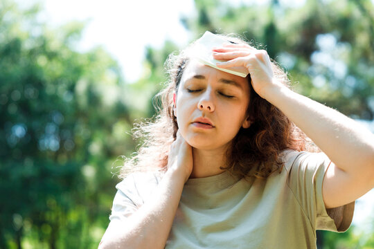 Young Woman Having Hot Flash And Sweating In A Warm Summer Day.