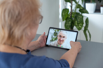 telemedicine concept, old woman with tablet pc during an online consultation with her doctor in her...
