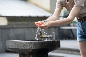 Drinking water flowing through city saves in hottest summer weather. Drops of water streaming up on...