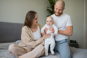 Happy family. Portrait of caucasian smiling mother father and newborn baby hugging at home. Motherhood. Loving parents mom and dad enjoy taking care of a little child. healthy child care