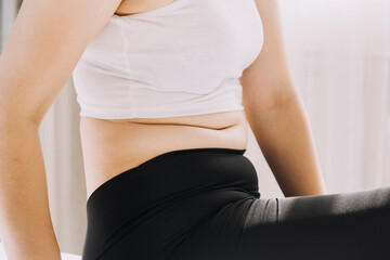 Beautiful fat woman with tape measure She uses her hand to squeeze the excess fat that is isolated on a white background. She wants to lose weight, the concept of surgery and break down fat under the