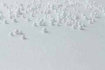 white beads of different sizes on a white background,