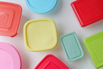 food containers on white background, container with red lid, container with blue lid, container with pink lid