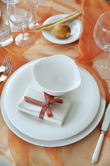 Table set in orange organza for a wedding banquet