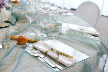 Detail of a table set in sea water color organza for a wedding banquet