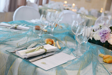Detail of a table set in sea water color organza for a wedding banquet